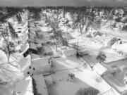 In this drone image, snow blankets a neighborhood, Sunday, Dec. 25, 2022, in Cheektowaga, N.Y.