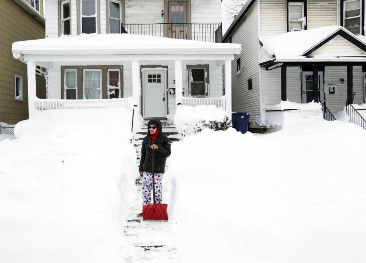 Raymond Santiago observes the snow in his neighborhood after shoveling snow by his front door in Buffalo, N.Y., on Tuesday, Dec. 27, 2022. Santiago, who's been in Buffalo for 35 years, says this is one of the worst snowstorms he's seen in the city.