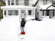 Raymond Santiago observes the snow in his neighborhood after shoveling snow by his front door in Buffalo, N.Y., on Tuesday, Dec. 27, 2022. Santiago, who's been in Buffalo for 35 years, says this is one of the worst snowstorms he's seen in the city.