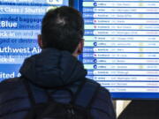 A passenger checks flight departures showing cancellations at Laguardia Airport, Friday Dec. 23, 2022, in New York.