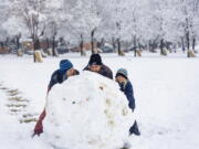 Sal Wood, Blake Wood and Jacobi Wood, 6, roll the largest snowball at Camel's Back Park in Boise, Idaho, on Monday, Dec. 12, 2022, after 2.5 inches of snow fell overnight according to the National Weather Service. No more snow is in the forecast for the Boise area this week, but temperatures are expected to drop to as low as 6 degrees by Saturday night. (Sarah A.