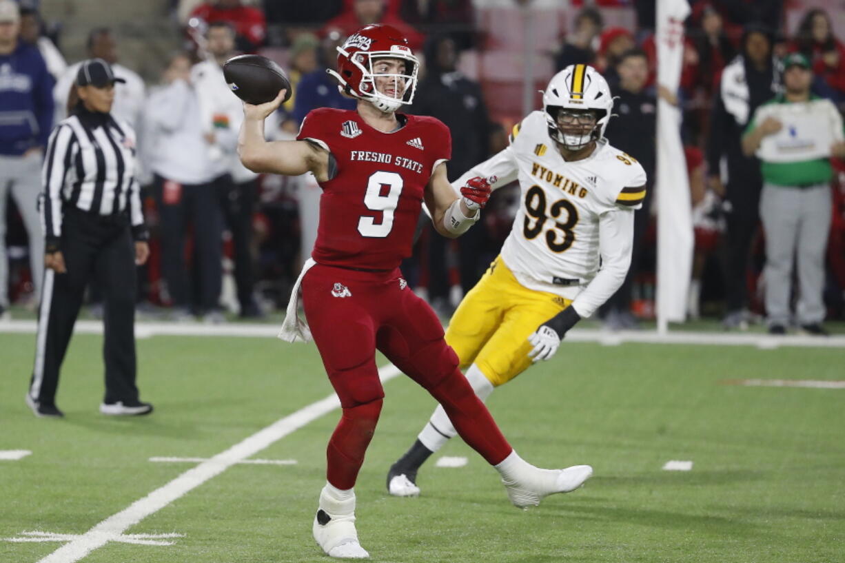 Fresno State Jake Haener scrambles against Wyoming defensive end DeVonne Harris during the second half of an NCAA college football game in Fresno, Calif., Friday, Nov. 25, 2022.