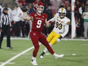 Fresno State Jake Haener scrambles against Wyoming defensive end DeVonne Harris during the second half of an NCAA college football game in Fresno, Calif., Friday, Nov. 25, 2022.