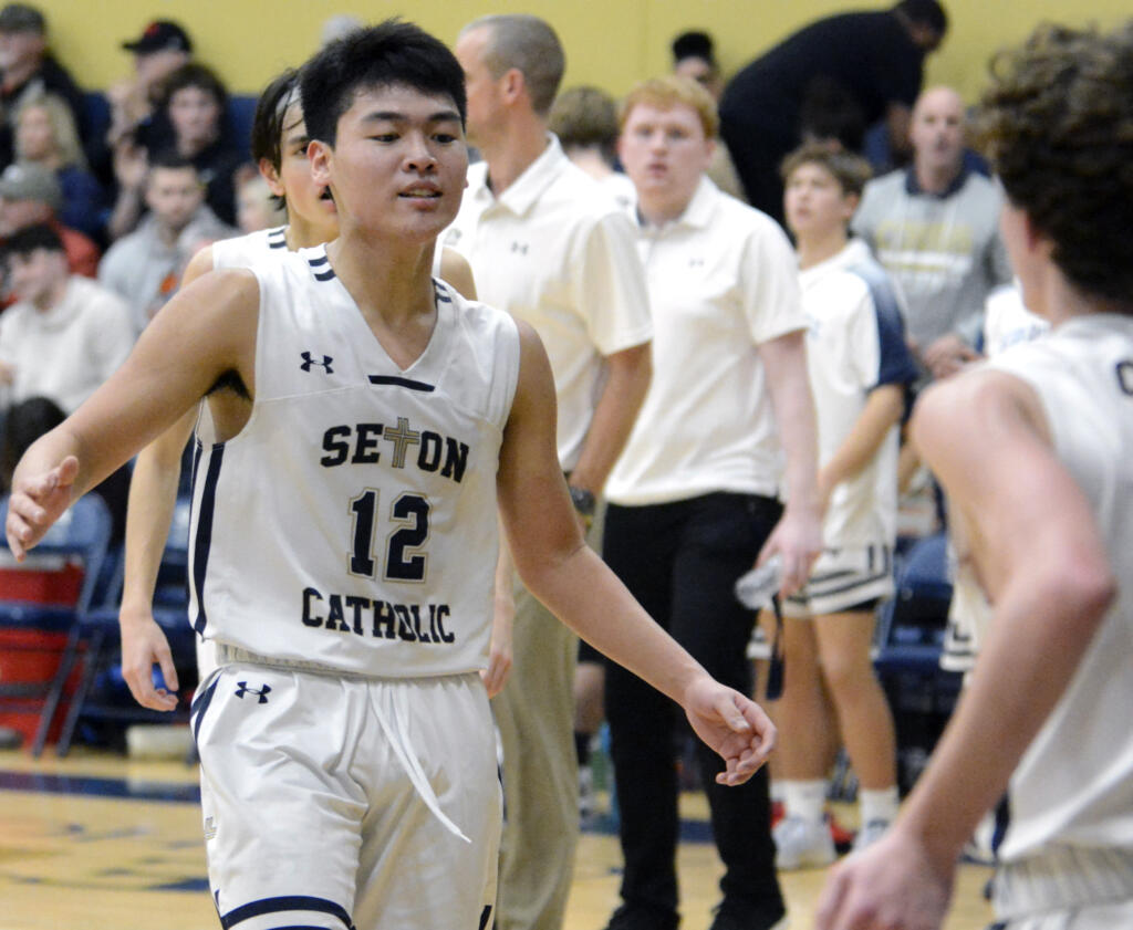 Seton Catholic’s Lance Lee, left, high fives teammate Brady Angelo, right, at halftime of a Trico League boys basketball game  against King’s Way Christian on Thursday, Jan. 12, 2023, in Vancouver.