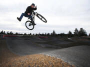 Brandon Giessinger, of Bend, launches a one-footed air over a gap while riding on the bike pump track at Big Sky Sports Park in Bend, Oregon.