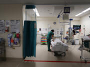 Jenny Sze, ED Registrar checks in with a patient at St Vincent's Hospital Emergency Department on December 04, 2021, in Sydney, Australia. To combat infection spread the hospital set up a separate COVID-19 section of the emergency department, utilizing a newly built section of the hospital to have a Red (COVID-19) zone and a Green (general emergency zone). Staff expects the demand for ongoing treatment will continue to grow as an estimated 30% of people who contract COVID-19 suffer persistent symptoms, known as 'long COVID'.