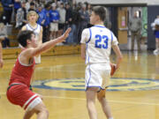 La Center’s Logan Rainey, right, looks to move the ball in the first half of a Trico League boys basketball game against Castle Rock on Wednesday, Jan. 18, 2023, at La Center High School.