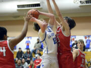 La Center’s Austin Nixon (12) looks to go up for a shot over Castle Rock’s James Montgomery (23) in a Trico League boys basketball game on Wednesday, Jan. 18, 2023, at La Center High School.