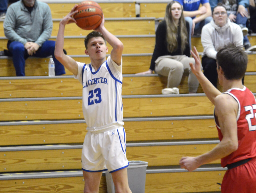 La Center’s Logan Rainey, left, shoots a 3-pointer as Castle Rock’s James Montgomery raises his hand to defend during a Trico League boys basketball game on Wednesday, Jan. 18, 2023, at La Center High School.