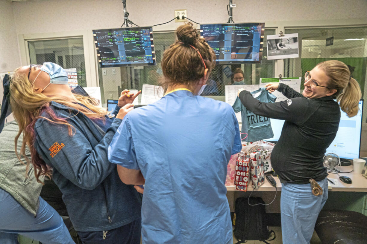 Aubrey Schmeider, left, shares a laugh with her fellow nurses during a surprise baby shower held in the nurse's station at the ER at Meadville Medical Center, on Tuesday, Dec. 13, 2022.