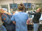 Aubrey Schmeider, left, shares a laugh with her fellow nurses during a surprise baby shower held in the nurse's station at the ER at Meadville Medical Center, on Tuesday, Dec. 13, 2022.