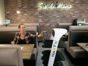 CarlaRae Arneson of Lynnwood grabs a tea press full of fresh tea from Peanut the server robot at Sushi Hana on Jan. 5 in Lynnwood.