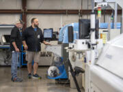 Kevin Syverson, left, and Chase Kleinschmidt of Silicon Forest Electronics demonstrate a pick-and-place machine.