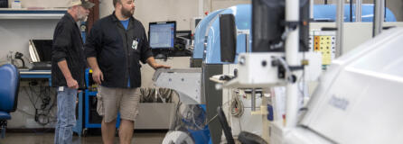 Kevin Syverson, left, and Chase Kleinschmidt of Silicon Forest Electronics demonstrate a pick-and-place machine.