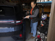 Phil Hays of Salmon Creek demonstrates how he charges his 2023 Volkswagen ID.4 electric vehicle. Hays had to regroup after one dealership slapped a $7,500 mark-up on an ID.4 he'd ordered months before.