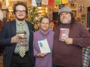 Angelo Luna, from left, Toni Lumbrazo Luna and Christopher Luna display their respective books at home in Hazel Dell. The family members have all authored books of poetry.