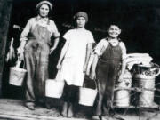 Margaret Eldred, left, stands next to an unidentified girl and boy at the entrance of a milking barn. There’s a cow in the left side background and milk containers on the right. During the Depression, dairy farming was the most prominent business in Clark County, boosting the local economy by $4 million to $5 million a year. When distributors reduced payments for raw milk to increase profits, the farmers rebelled by blacklisting them, starting a milk war that turned violent in 1931.