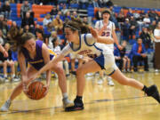 Columbia River senior Kinzi Drake, left, grabs a loose ball before Ridgefield senior Megan Weber on Tuesday, Jan. 10, 2023, during the Rapids’ 41-39 win against Ridgefield at Ridgefield High School.