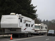 A motorist traveling north on Fort Vancouver Way passes two recreational vehicles parked near Clark College, an area that has become home for several people living in their vehicles.