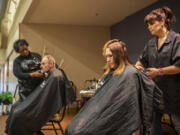 The Barbers hairstylists Debi Norman, right, and Lynell Felix, left, cut the hair of Alicia Haddix, second from right, and Arthur Walton, on Thursday as part of Project Homeless Connect at St. Joseph Catholic Church. The event brings multiple services under one roof for a day to help out those experiencing homelessness.