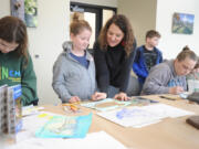 Art teacher Michelle Hankins, standing at right, helps her daughter Ruby decide what colors would best complement her duck drawing during a Saturday art workshop at the Ridgefield National Wildlife Refuge.