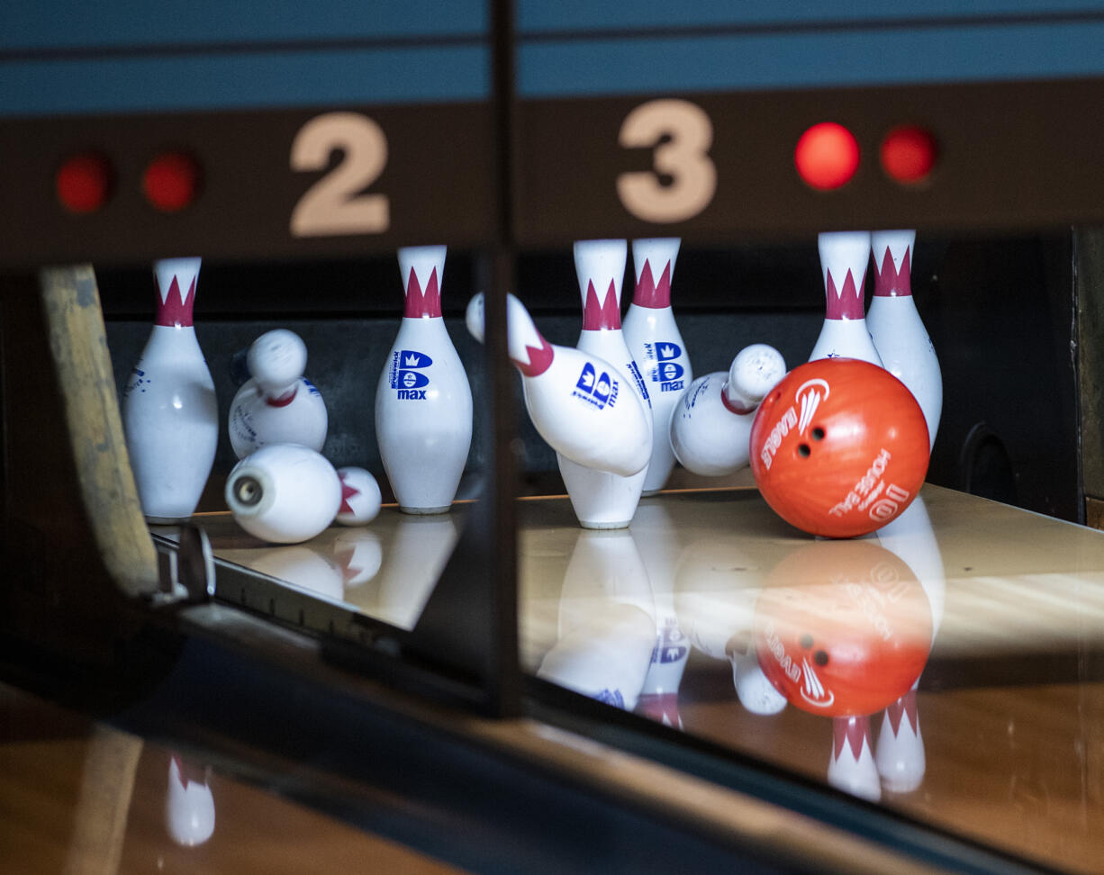 A ball crashes into pins Friday, Jan. 27, 2023, during the 4A/3A District Bowling Tournament at Husted’s Hazel Dell Lanes.