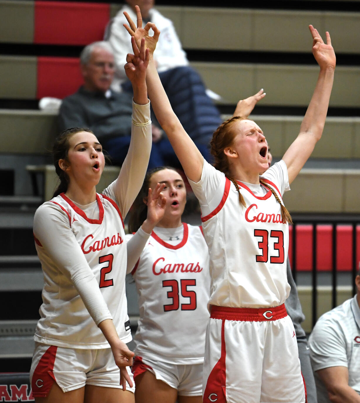 Camas sophomores Kendall Mairs, left, Keirra Thompson, center, and junior Addison Harris celebrate a basket Tuesday, Jan. 31, 2023, during the Papermakers’ 77-34 win against Skyview at Camas High School.