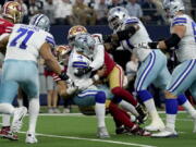 FILE -Dallas Cowboys quarterback Dak Prescott (4) is sacked by San Francisco 49ers defensive end Nick Bosa, center left rear, with help in the first half of an NFL wild-card playoff football game in Arlington, Texas, Sunday, Jan. 16, 2022. The 49ers-Cowboys playoff history is a rich one from back-to-back conference title games in the early 1970s, the iconic '??Catch'?? in the 1981 season and then the heated rivalry in the 1990s when the Cowboys won the first two meetings on the way to Super Bowl titles and then the Niners took the third game.