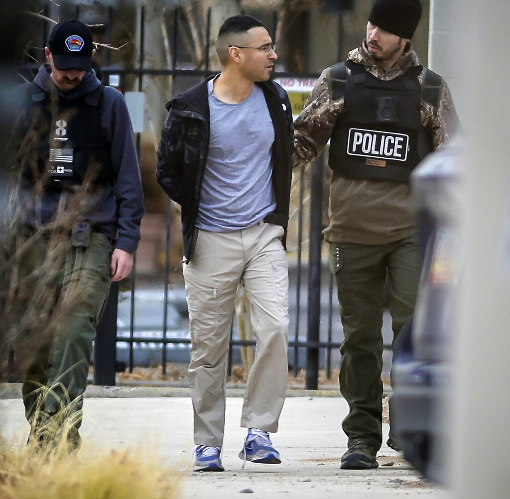 Solomon Pena, center, a Republican candidate for New Mexico House District 14, is taken into custody by Albuquerque Police officers, Monday, Jan. 16, 2023, in southwest Albuquerque, N.M. Two years since the attack on the U.S. Capitol, a series of drive-by shootings targeting Democrats in New Mexico is a violent reminder that the false claims about a stolen election persist in posing a danger to public officials and the country’s democratic institutions. No one was hurt in the Albuquerque attacks. (Roberto E.