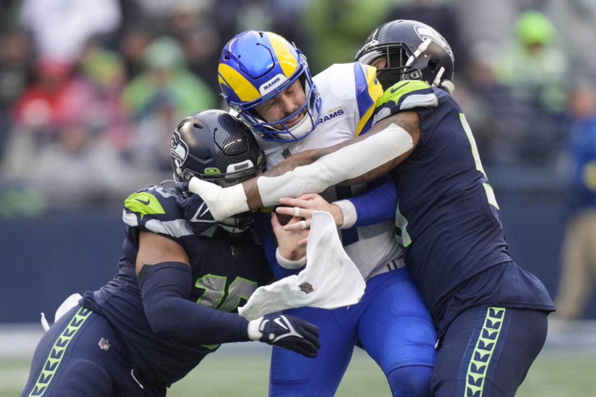 Los Angeles Rams quarterback Baker Mayfield (17) throws as Seattle Seahawks defensive tackle Quinton Jefferson (77) closes in during the second half of an NFL football game Sunday, Jan. 8, 2023, in Seattle.