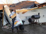 Mario Mendoza carries items out of a friend's storm-damaged home Tuesday, Jan. 24, 2023, in Pasadena, Texas. A powerful storm system took aim at Gulf Coast Tuesday, spawning tornados that caused damage east of Houston. (AP Photo/David J.