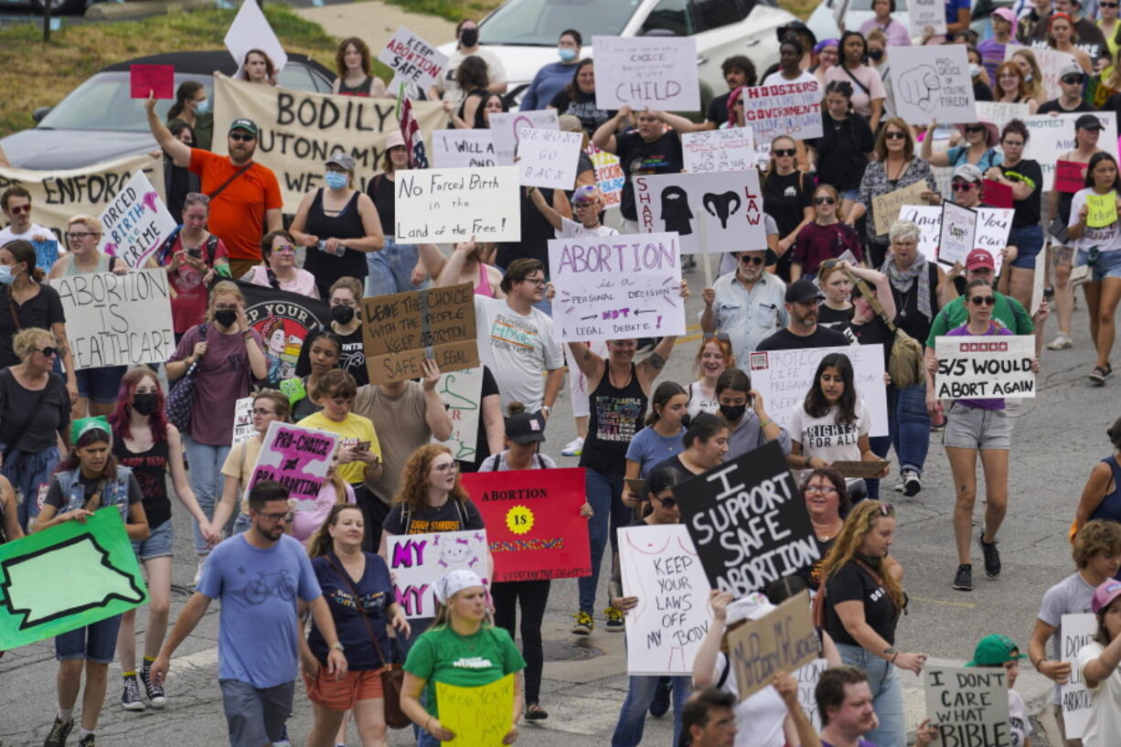 FILE - Abortion-rights protestors march between the Indiana Statehouse and the Indiana State Library where Vice President Kamala Harris was meeting with Indiana legislators to discuss reproductive rights in Indianapolis on July 25, 2022. The fate of Indiana's Republican-backed abortion ban goes Thursday, Jan. 19, 2023, before the state Supreme Court as it hears arguments on whether it violates privacy protections under the state constitution.