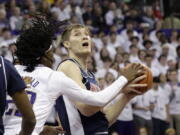 Arizona forward Azuolas Tubelis, right, looks to the basket with Washington guard Keyon Menifield defending during the first half of an NCAA college basketball game, Saturday, Jan. 28, 2023, in Seattle.