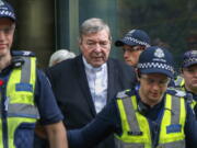 FILE - Cardinal George Pell, center, the most senior Catholic cleric to face sex charges, leaves court in Melbourne, Australia, May 2, 2018. Pell, who was the most senior Catholic cleric to be convicted of child sex abuse before his convictions were later overturned, has died Tuesday, Jan. 10, 2023, in Rome at age 81.