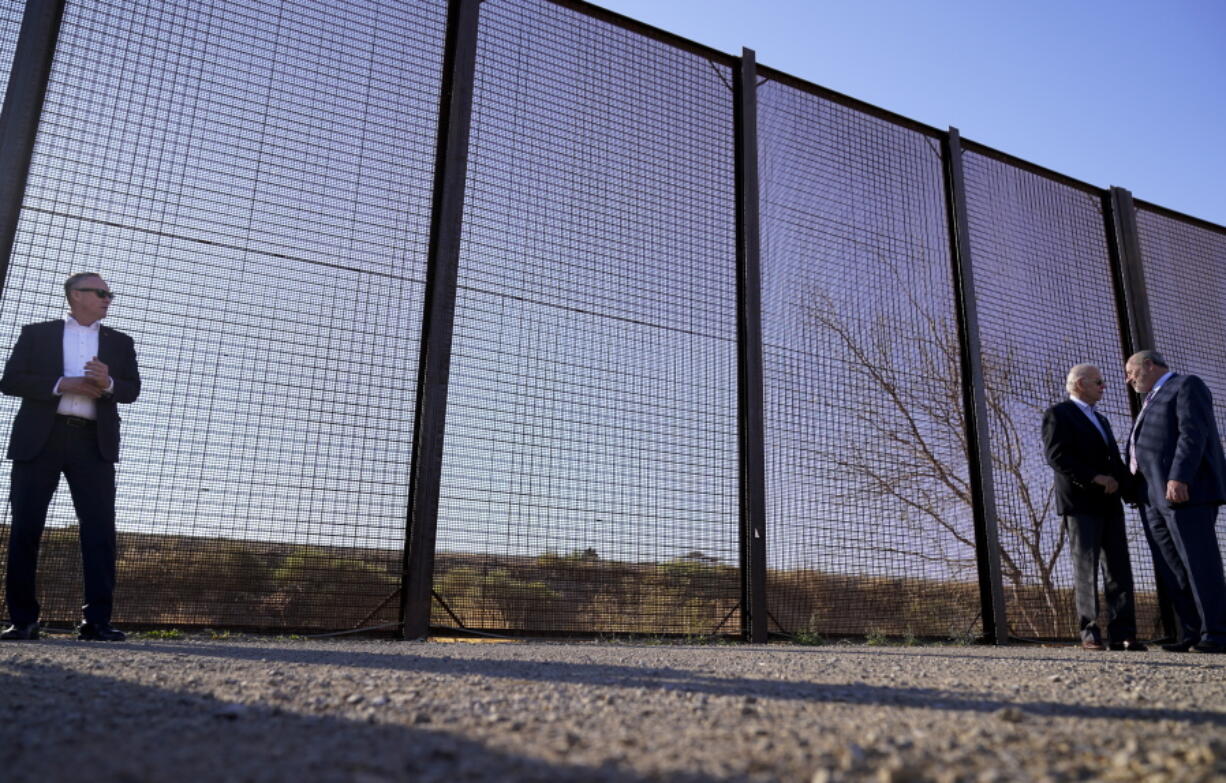 President Joe Biden talks with Oscar Leeser, Mayor of the City of El Paso, Texas, as they stand near a stretch of the U.S.-Mexico border in El Paso Sunday, Jan. 8, 2023.