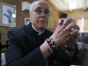 Bishop Mark Seitz of El Paso sits for a portrait in his office in El Paso, Texas, on Monday, April 4, 2022. The friendship bracelets on his wrist were braided by girls housed at a shelter on nearby Fort Bliss Army base for unaccompanied minors who crossed the U.S.-Mexican border. "Immigrants have had the experience of leaving everything that helped them to feel at home and secure in this life behind, and to depend utterly on God as they journey. ... They have so much to teach us about how God will accompany us on our journey," Seitz says.