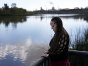 Moonlight Pulido stands by the shore at Harbor Lake Wednesday, Dec. 7, 2022, in Los Angeles. California is paying reparations to victims, mostly women, who were either forcibly or coercively sterilized by the government. Pulido was sterilized while incarcerated in 2005.