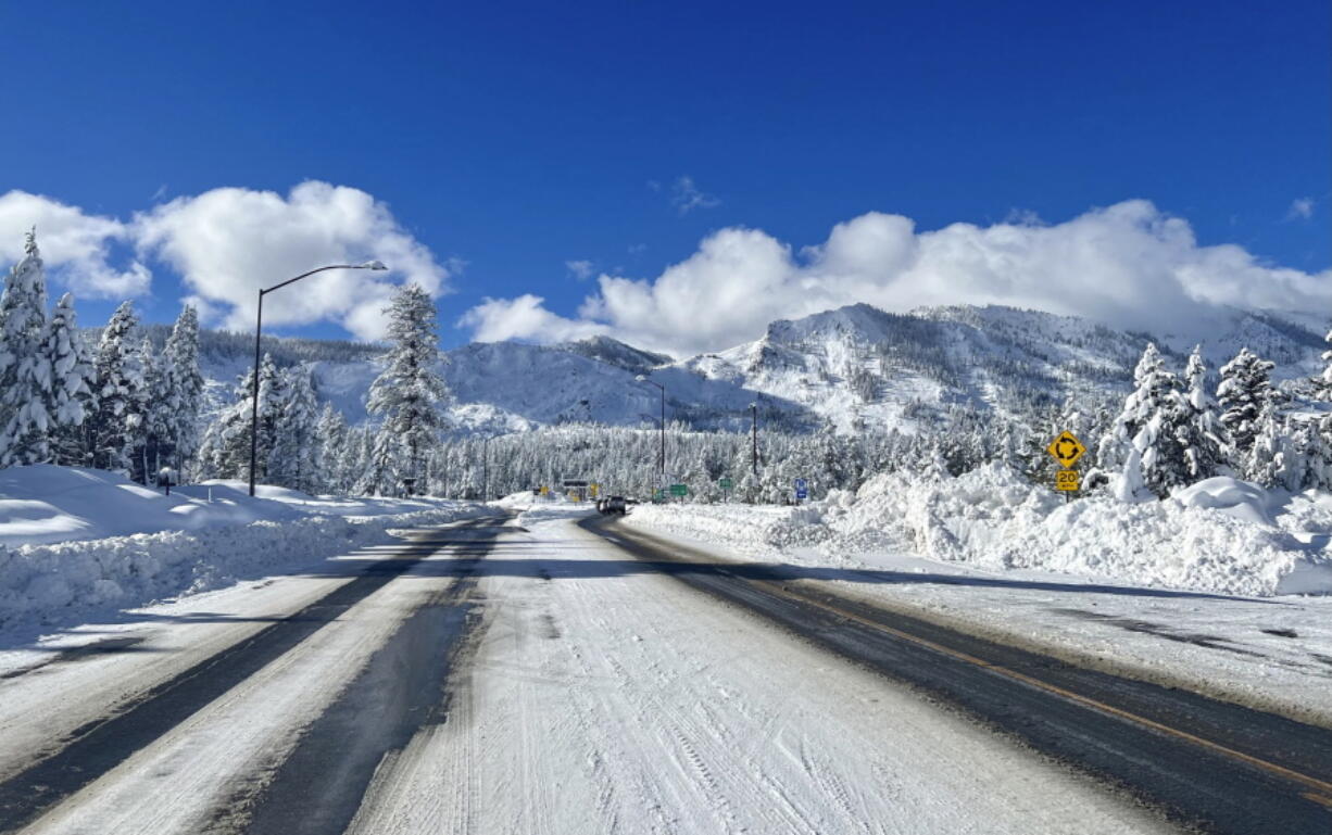 This Sunday, Jan. 1, 2023, photo released by Caltrans District 3, shows Sierra highway back open but chain controls remain in effect as crews clean up in South Lake Tahoe, Calif. California was drying out and digging out on New Year's Day after a powerful storm brought drenching rain or heavy snowfall to much of the state, snarling traffic and closing highways.