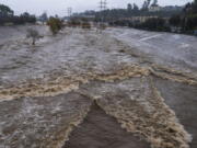 FILE - The Los Angeles River flows downstream in Los Angeles, Jan. 14, 2023. In Los Angeles, a complex system of dams and paved flood control channels including the river were designed to steer water away from roads and buildings and out to sea as fast as possible. But with water sources becoming scarce, efforts are underway to begin capturing and treating some of the runoff for irrigation or to inject in aquifers.