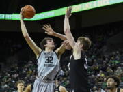 Oregon center Nate Bittle (32) shoots over Colorado center Lawson Lovering, center right, during the first half of an NCAA college basketball game Thursday, Jan. 26, 2023, in Eugene, Ore.