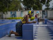 A woman prays outside the Cathedral Notre Dame du Congo in Kinshasa, Democratic Republic of the Congo Saturday Jan. 28, 2023. Pope Francis will be in Congo and South Sudan for a six-day trip starting Jan, 31, hoping to bring comfort and encouragement to two countries that have been riven by poverty, conflicts and what he calls a "colonialist mentality" that has exploited Africa for centuries.