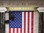 FILE - "In God We Trust" is engraved in stone above a U.S. flag in the House of Representatives chamber at the Capitol in Washington on Tuesday, March 1, 2022. Even though nearly three in 10 Americans claim no religious affiliation -- a rate that has steadily risen in recent years -- only two of the 534 incoming members of Congress will admit to as much.