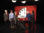 Siegfried Hecker, from left, Daniel Holz, Sharon Squassoni, Mary Robinson and Elbegdorj Tsakhia with the Bulletin of the Atomic Scientists, remove a cloth covering the Doomsday Clock before a virtual news conference at the National Press Club in Washington, Tuesday, Jan. 24, 2023. The Bulletin of the Atomic Scientists announced that it has moved the minute hand of the Doomsday Clock to 90 seconds to midnight.