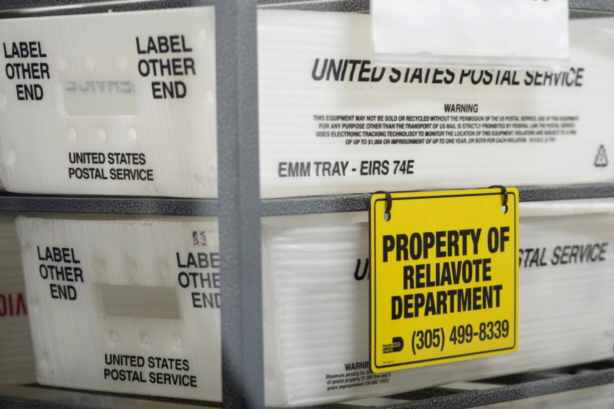 U.S. Postal Service bins are lined up to hold vote-by-mail ballots for scanning during the midterm election at the Miami-Dade County Elections Department, Nov. 8, 2022, in Miami. The U.S. Postal Service delivered more than 54 million ballots for the midterm election, with nearly 99% of ballots delivered to election officials within three days, officials said Monday, Jan. 9, 2023.