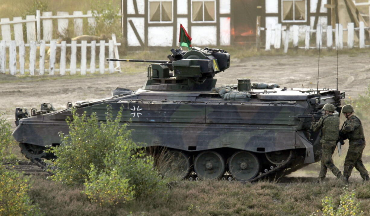 FILE -- Soldiers follow a Marder infantry fighting vehicle during a demonstration event held for the media by the German Bundeswehr in Bergen near Hannover, Germany, Wednesday, Sept. 28, 2011. U.S. President Joe Biden and German Chancellor Olaf Scholz confirmed in a joint statement Thursday that the U.S. would provide Bradleys to Ukraine while Germany would provide Marder armored personnel carriers. The statement did not give the number of vehicles or the total cost of the aid package.