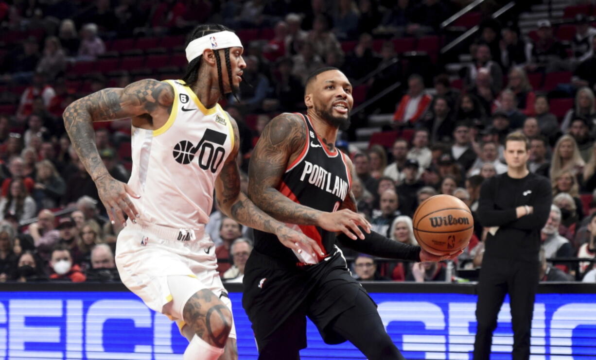 Portland Trail Blazers guard Damian Lillard, right, drives to the basket on Utah Jazz guard Jordan Clarkson, left, during the first half of an NBA basketball game in Portland, Ore., Wednesday, Jan. 25, 2023.