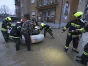 Firefighters evacuate people from a flooded area in northern Serb-dominated part of ethnically divided town of Mitrovica, Kosovo, Thursday, Jan. 19, 2023. Heavy rainfall this week across the Balkans has caused rivers to rise dangerously in Serbia, Bosnia, Kosovo and Montenegro, flooding some areas and threatening flood defenses elsewhere.