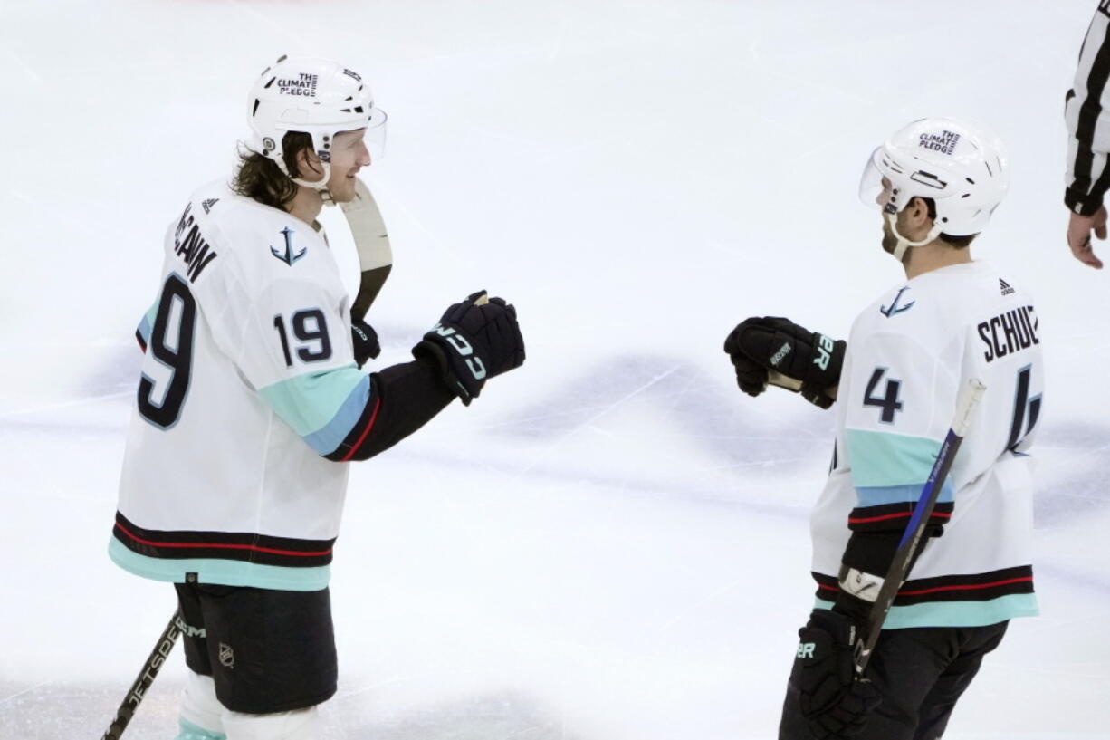 Seattle Kraken's Jared McCann (19) celebrates his hat trick with Justin Schultz during the third period of the team's NHL hockey game against the Chicago Blackhawks on Saturday, Jan. 14, 2023, in Chicago.