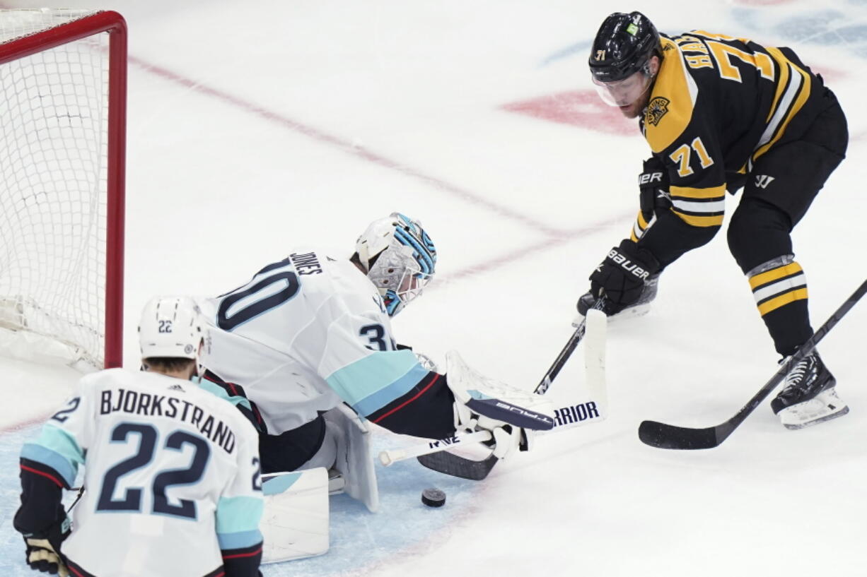 Boston Bruins left wing Taylor Hall (71) is unable to get the puck past Seattle Kraken goaltender Martin Jones (30) while Kraken right wing Oliver Bjorkstrand (22) watches during the second period of an NHL hockey game Thursday, Jan. 12, 2023, in Boston.