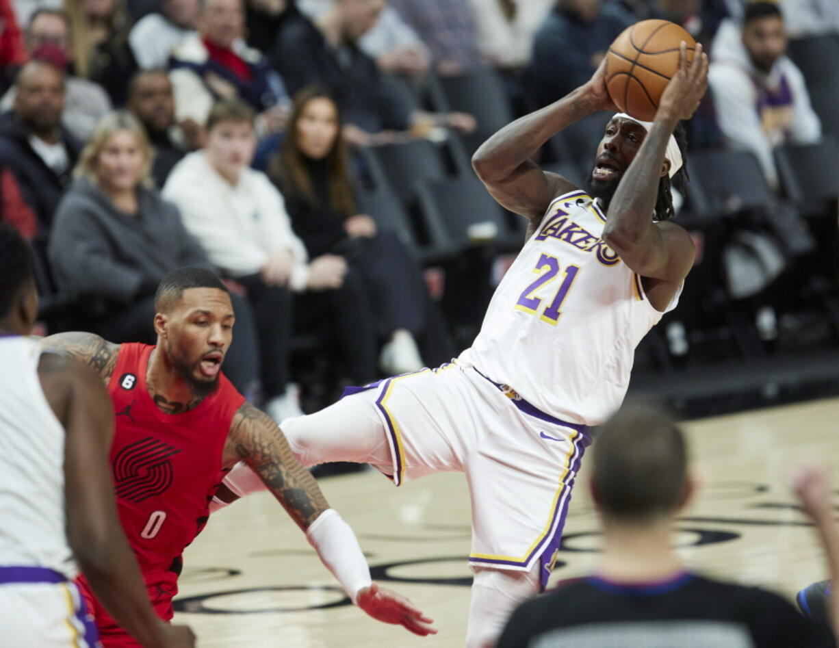 Los Angeles Lakers guard Patrick Beverley, right, shoots while being fouled by Portland Trail Blazers guard Damian Lillard during the second half of an NBA basketball game in Portland, Ore., Sunday, Jan. 22, 2023.